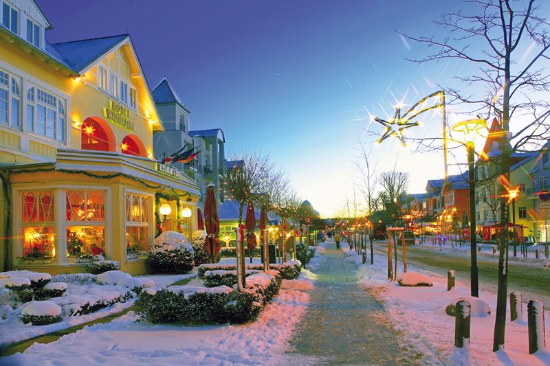 Winterlich geschmückte Szene in einem städtischen Bereich Verschneite Straße mit festlich beleuchteten Häusern und Dekorationen.