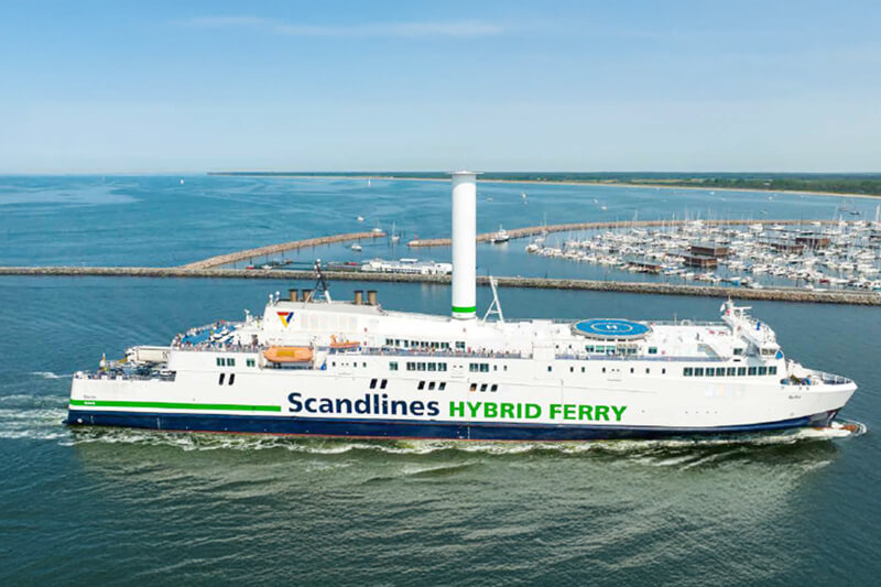 Scandlines Hybridfähre auf dem Wasser nahe eines Hafens Eine Scandlines Hybridfähre fährt in der Nähe eines Hafens auf offenem Wasser.